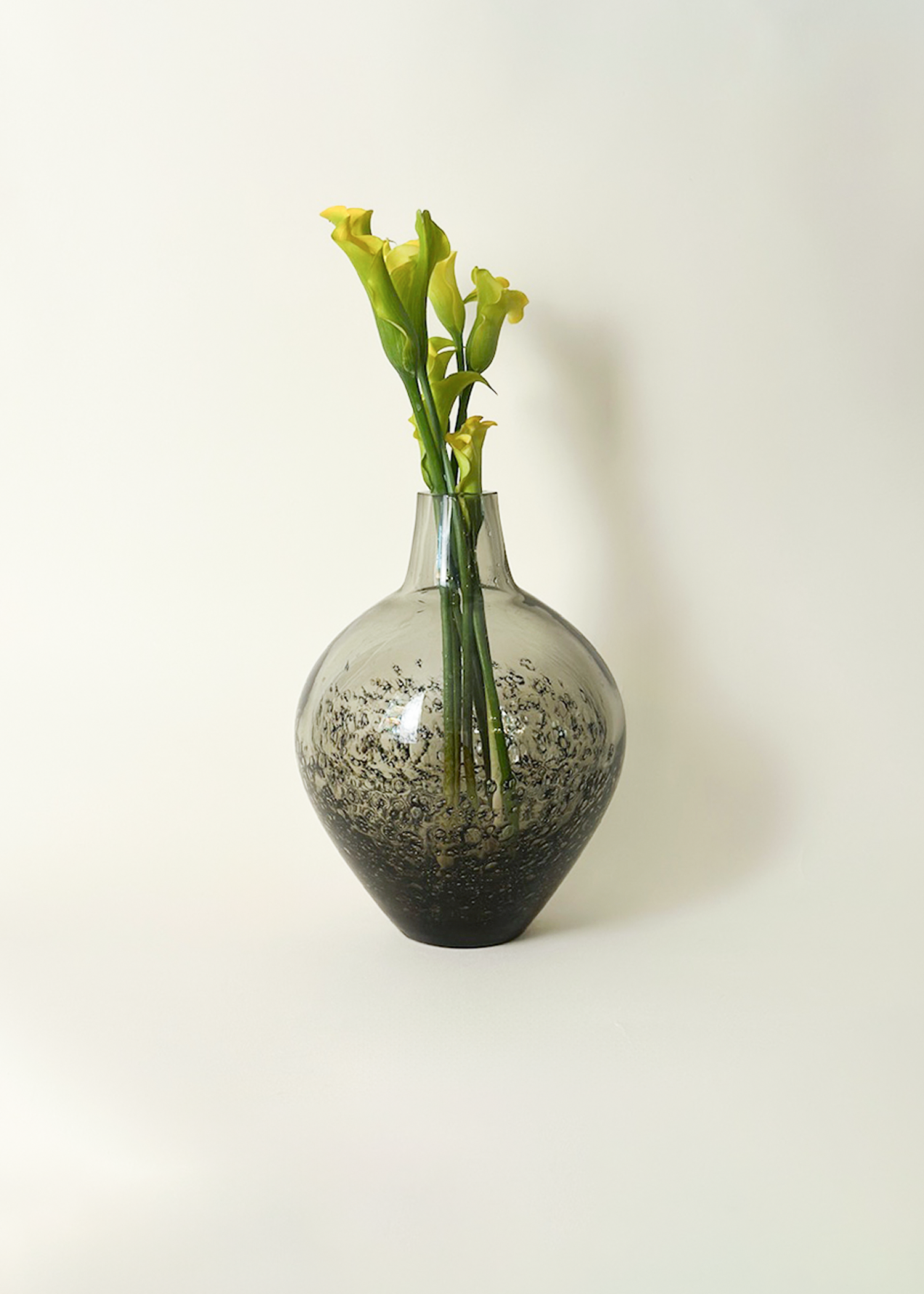Vintage smoked glass vase from the 1970s with handblown curved form, thick 3/8 inch glass, and sculptural silhouette. Ideal for mid century modern or minimalist interiors