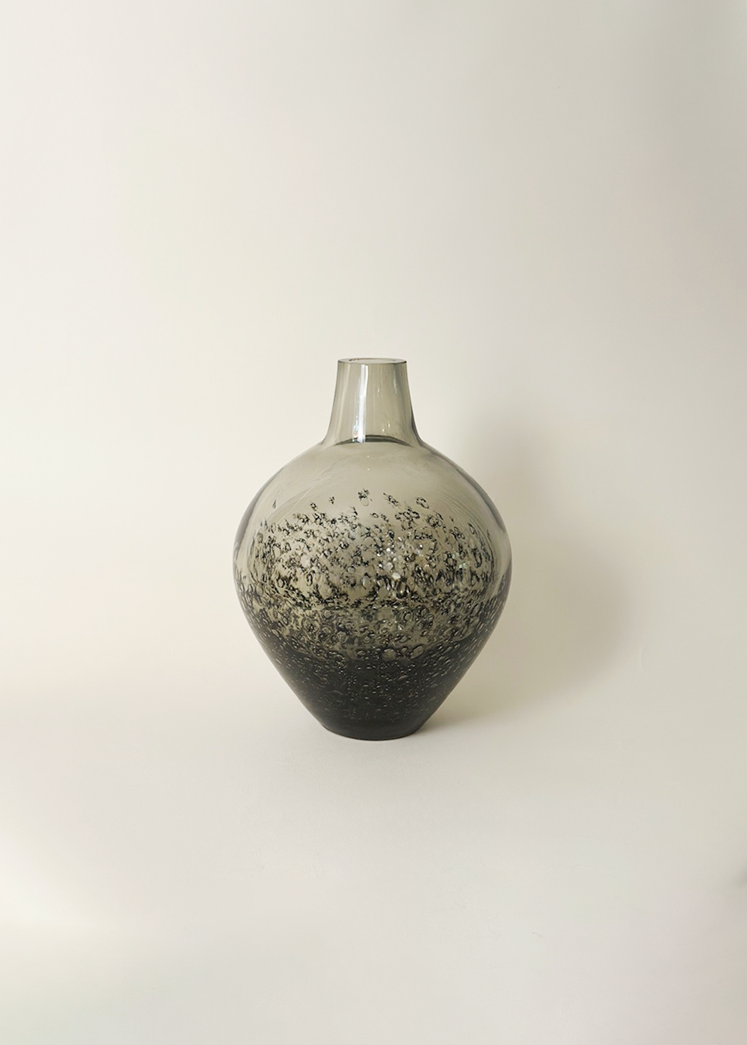 Vintage smoked glass vase from the 1970s with handblown curved form, thick 3/8 inch glass, and sculptural silhouette. Ideal for mid century modern or minimalist interiors