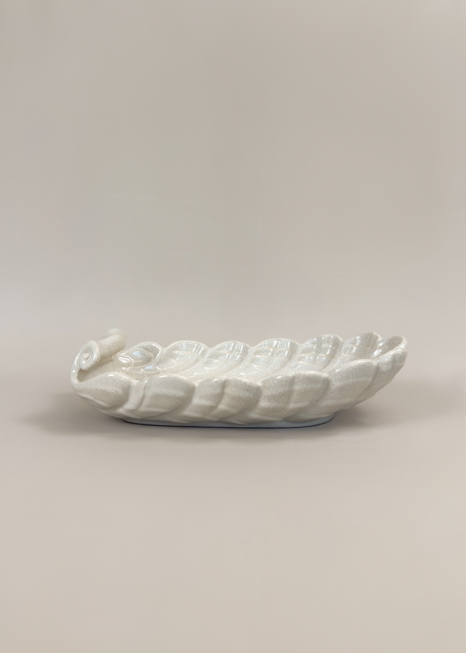 Vintage ceramic shell dish in matte white glaze with scalloped edges and organic wave contours. A decorative collectible for coastal, mid century or modern interiors perfect as a trinket tray or styling centerpiece.