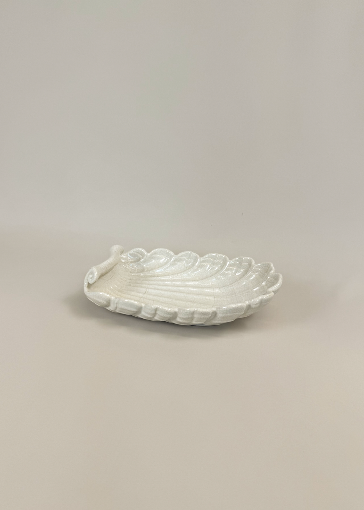 Vintage ceramic shell dish in matte white glaze with scalloped edges and organic wave contours. A decorative collectible for coastal, mid century or modern interiors perfect as a trinket tray or styling centerpiece.