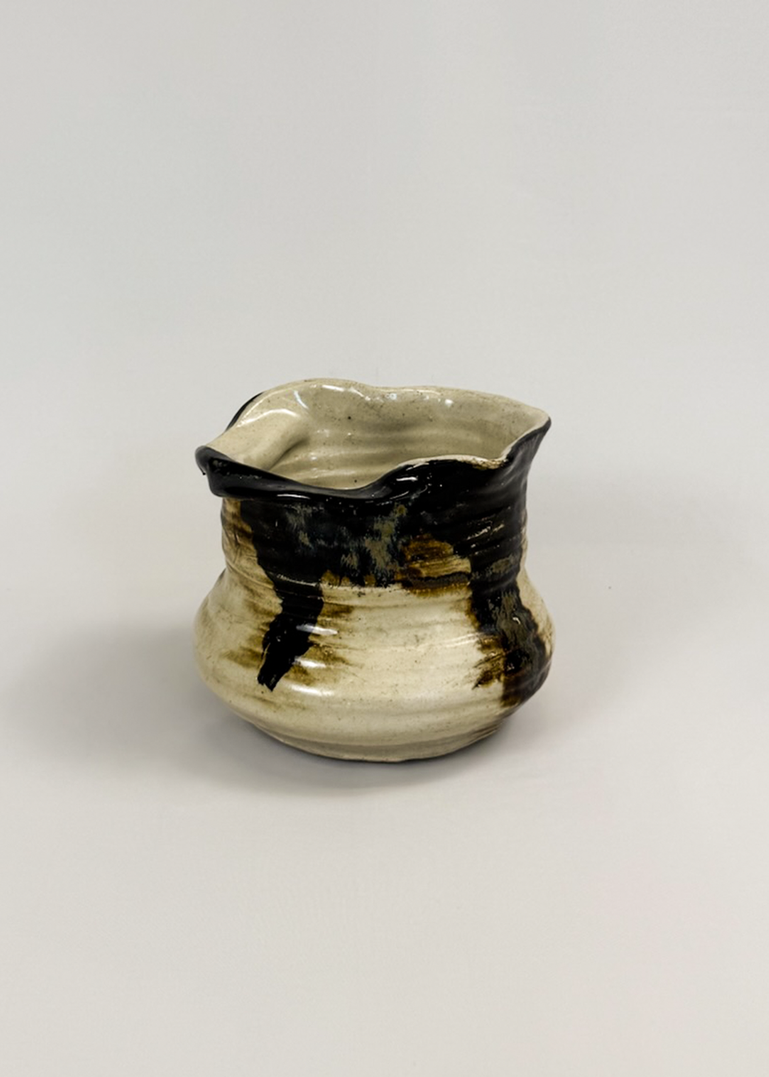 Abstract ceramic vase with sculptural curves and matte white glaze, showing organic silhouette and subtle shadow play. A collectible decorative design object for modern interiors