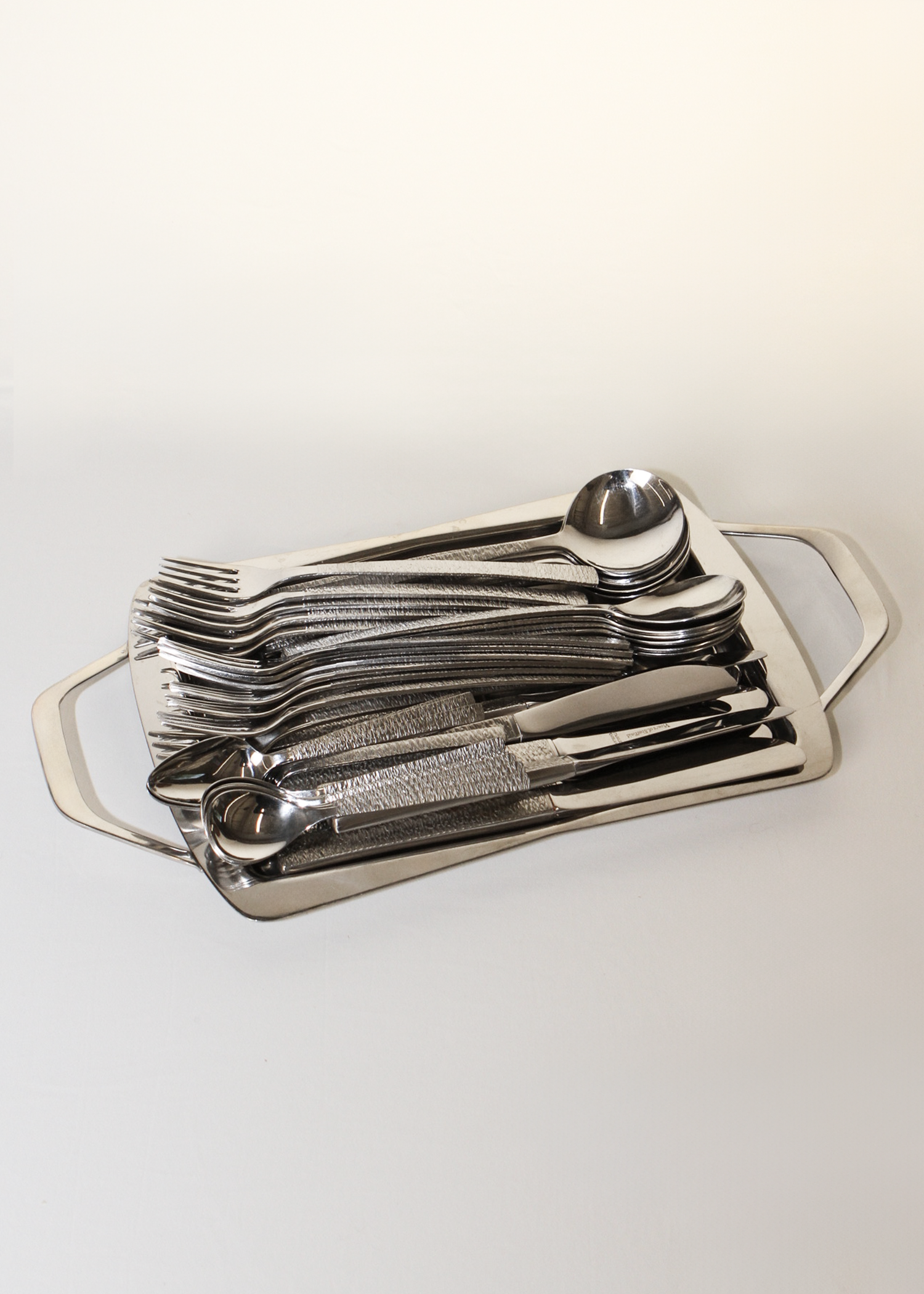 **Alt text:**
Set of 38-piece vintage flatware by Gerald Benney for Viners of Sheffield, elegantly arranged on a matte dark surface. Each piece features sleek, minimalist stainless steel construction and subtle British hallmarks, showcasing post-war modern design. Available at In Corso, Toronto’s marketplace for vintage and modern design.