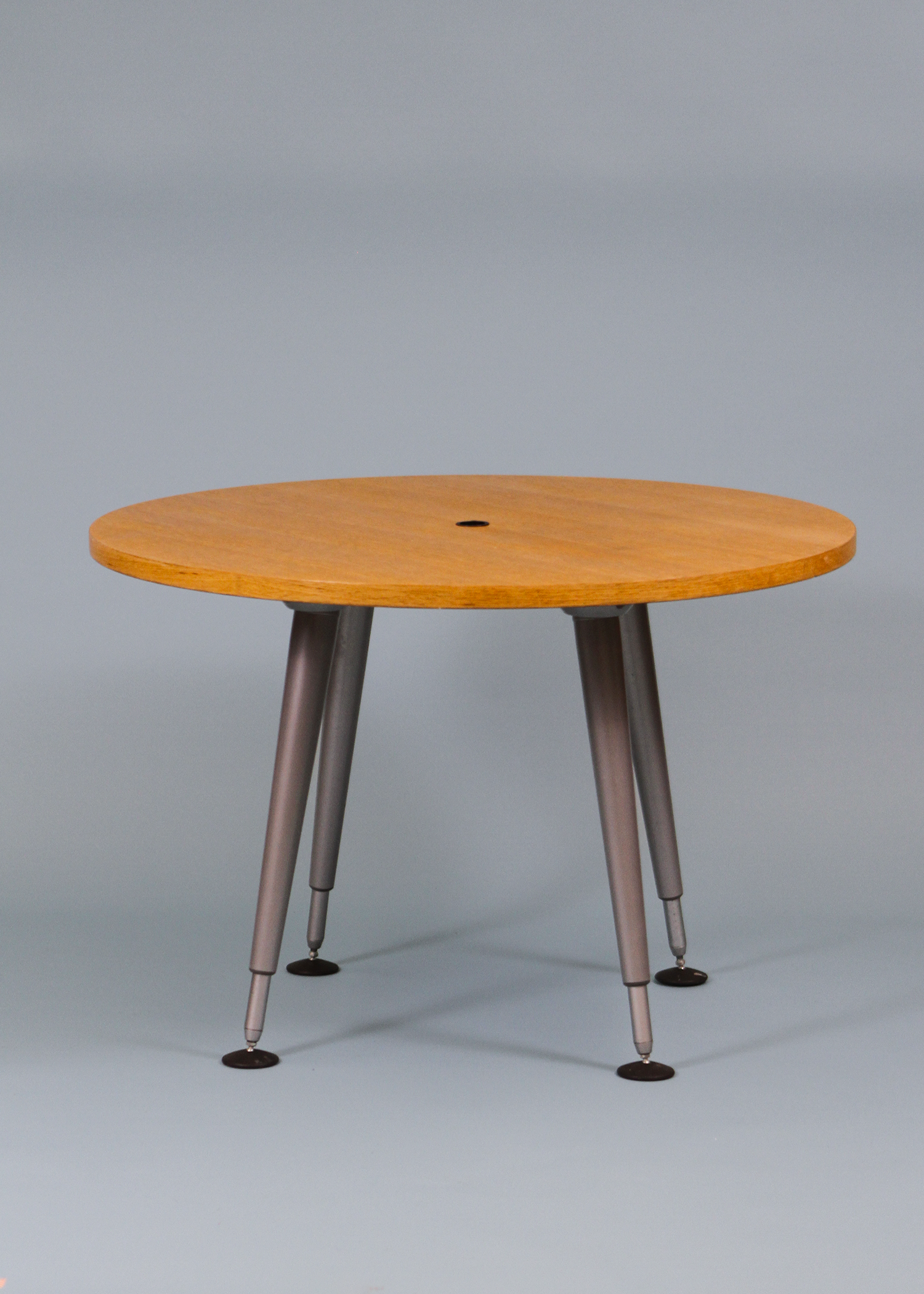 Adjustable round table with a warm wood veneer top and sculptural chrome legs that can be raised or lowered to suit your space. A versatile vintage piece that works as a compact dining table, statement side table, or elevated laptop station. Photographed on a neutral backdrop for clarity. Available at incorsostudio.com a vintage furniture platform in Toronto