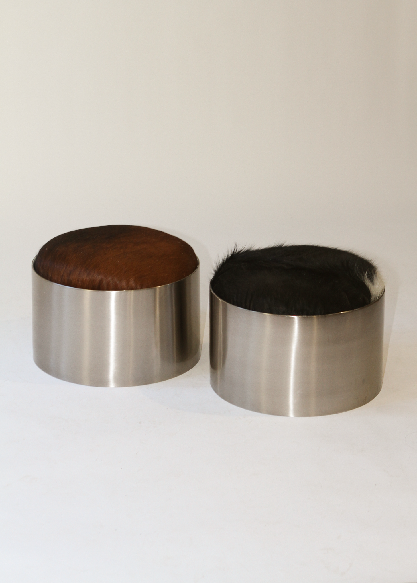 Cylindrical foot stool with leather cowhide pony hair top and chrome base on a white background - available on incorsostudio.com 