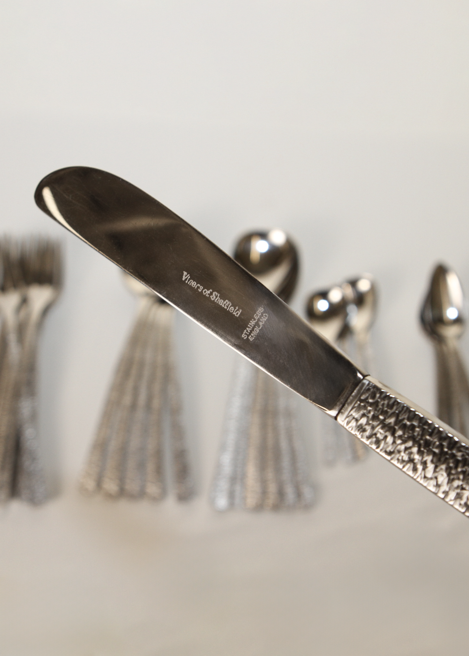 **Alt text:**
Set of 38-piece vintage flatware by Gerald Benney for Viners of Sheffield, elegantly arranged on a matte dark surface. Each piece features sleek, minimalist stainless steel construction and subtle British hallmarks, showcasing post-war modern design. Available at In Corso, Toronto’s marketplace for vintage and modern design.

