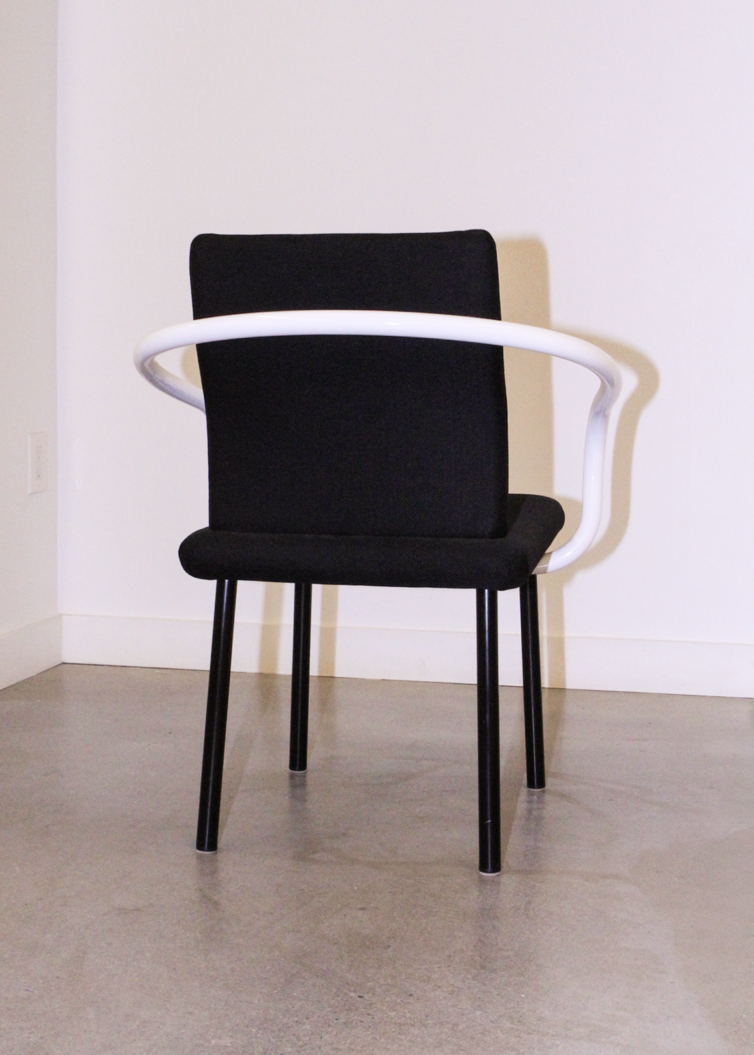 Pair of vintage Mandarin chairs by Ettore Sottsass for Knoll in black upholstery with sculptural white tubular arms. Collectible postmodern designer seating from 1986, perfect for mid century modern inspired interiors