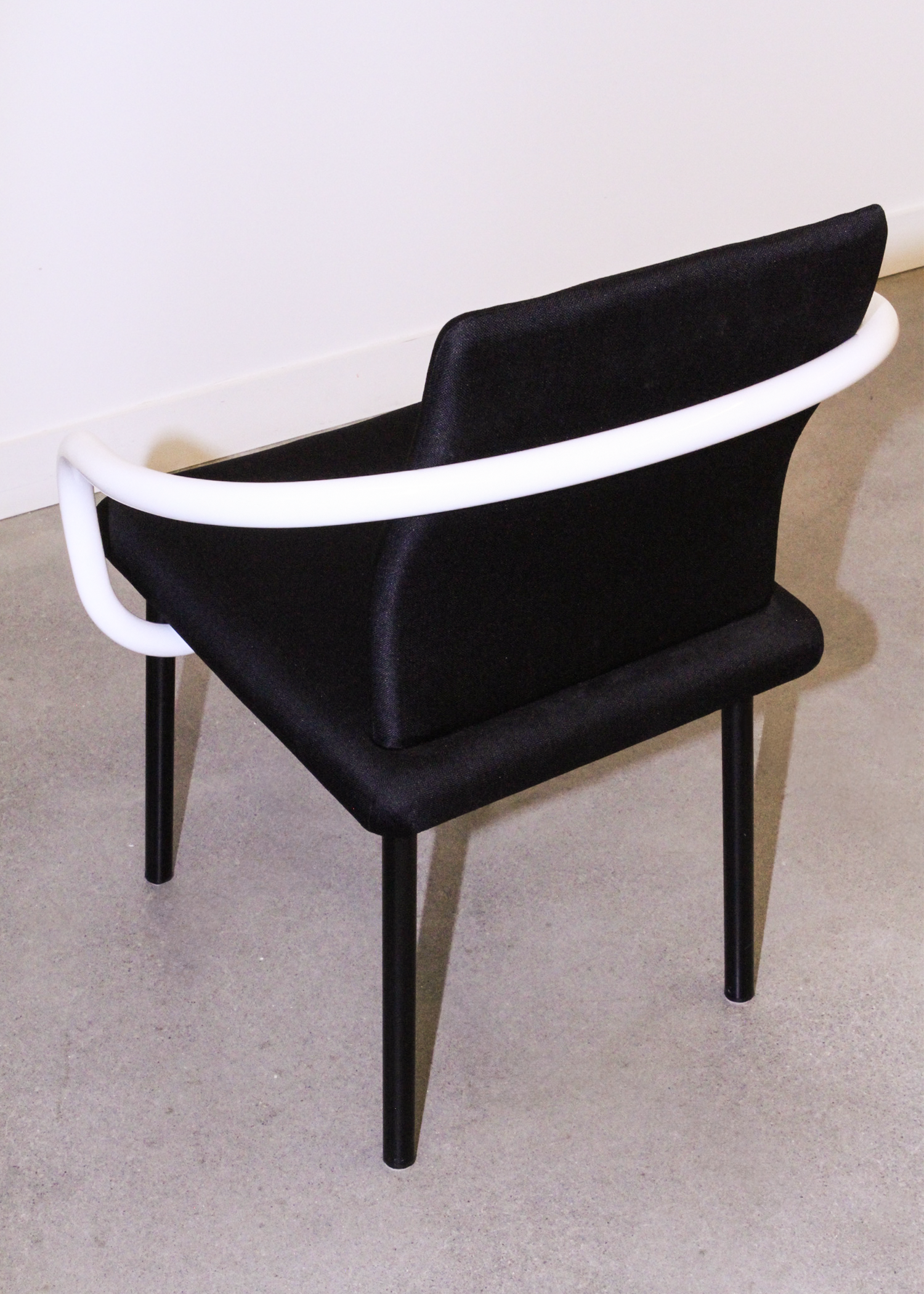 Pair of vintage Mandarin chairs by Ettore Sottsass for Knoll in black upholstery with sculptural white tubular arms. Collectible postmodern designer seating from 1986, perfect for mid century modern inspired interiors