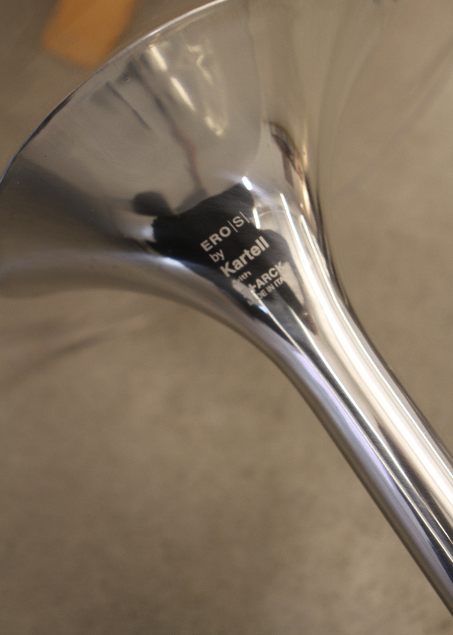 Metallic chair leg with 'Kartell' branding and 'Made in Italy' text. Philippe Starck for kartell clear office chair called "eros" with chrome base. mid-century modern vintage furniture style, sold by incorsostudio.com, a vintage furniture marketplace in toronto canada. 